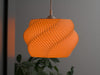 Vibrant orange wavy lampshade with a bold, pleated design, perfect for pendant light shades and statement lighting.