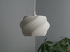 White pendant light shade with a sculptural wave pattern, ideal for contemporary home lighting setups.