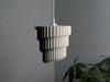 Minimalist white table lamp shade with a pleated ripple pattern, ideal for modern and classic interiors.