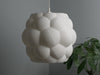 White wicker lamp shade with a pleated bubble pattern, perfect for boho and minimalist decor.